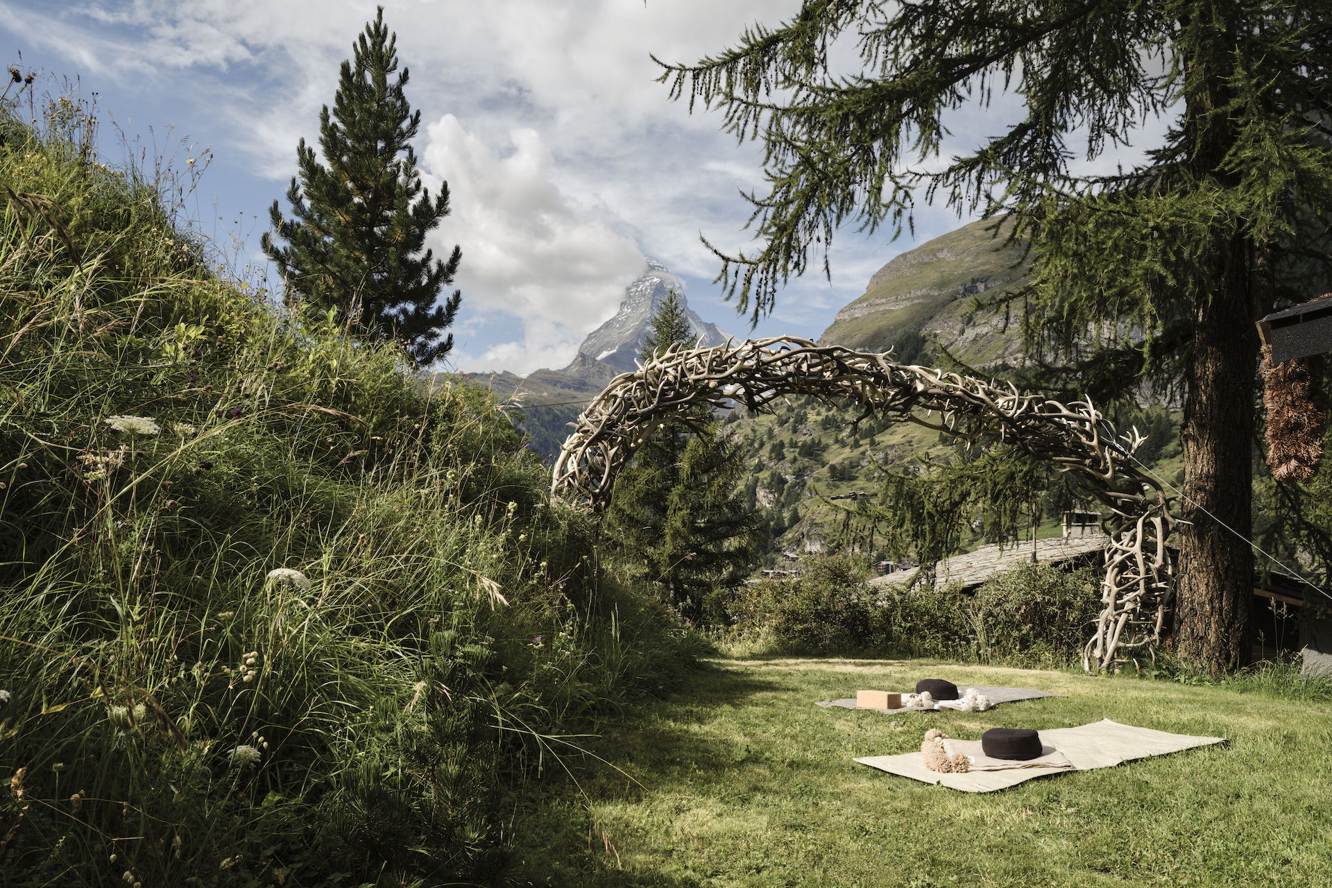 Yogamatten auf dem Vista Yoga Deck des Mountain Ashram Spa in einer atemberaubenden, grünen Landschaft Zermatts